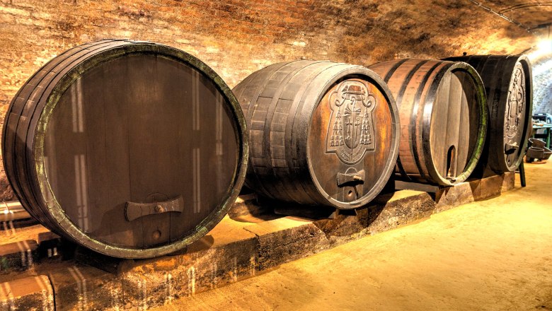 Wine barrels in a wine cellar with a brick ceiling.