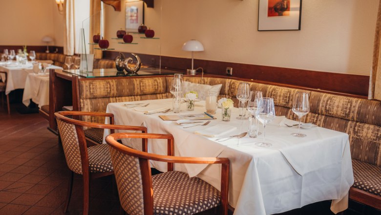 Elegant restaurant with a table setting, white tablecloths and stylish chairs.
