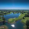 Aerial view of a golf course with water hazards and green fairways.