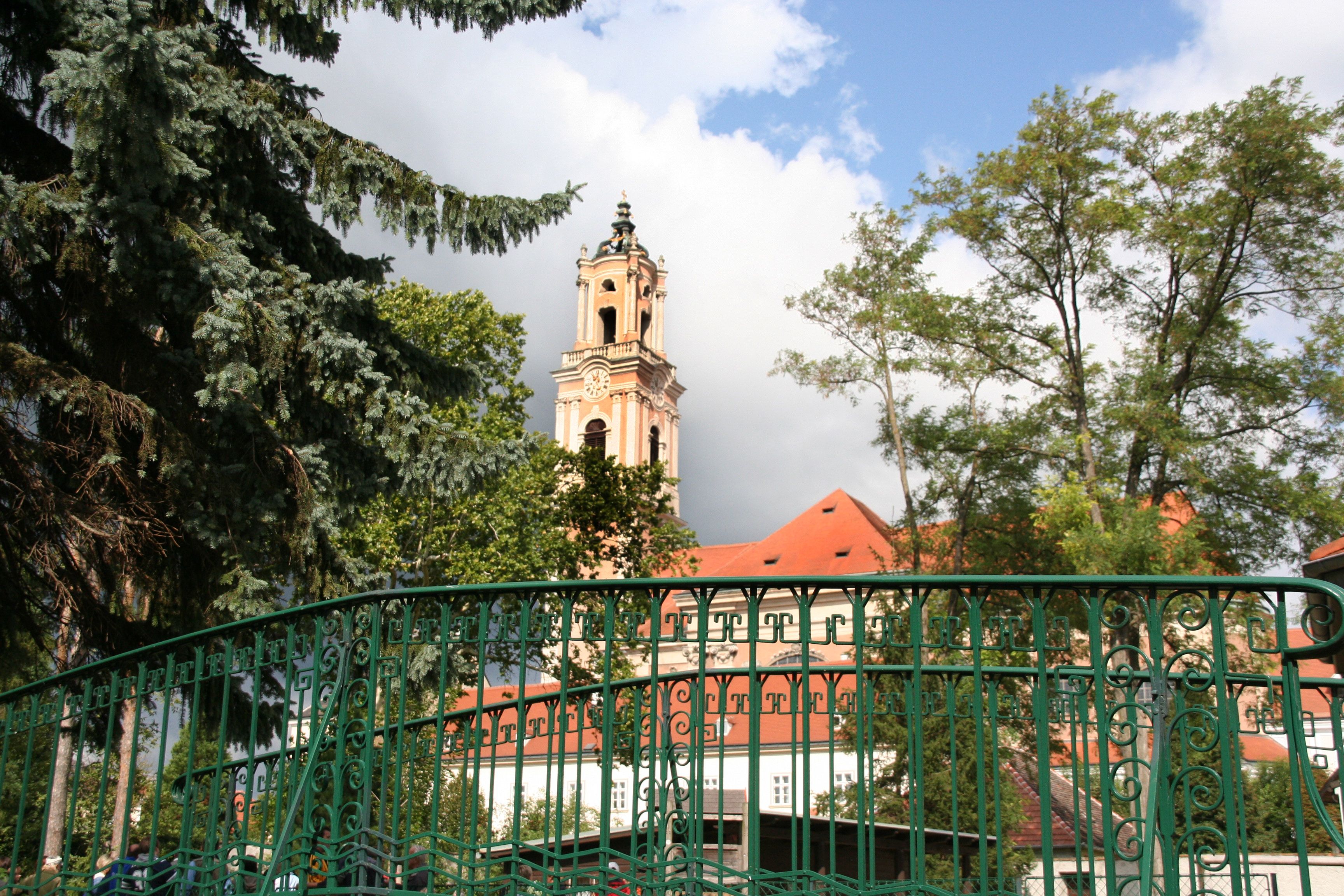 Herzogenburg Abbey with tower and green fence in the foreground.