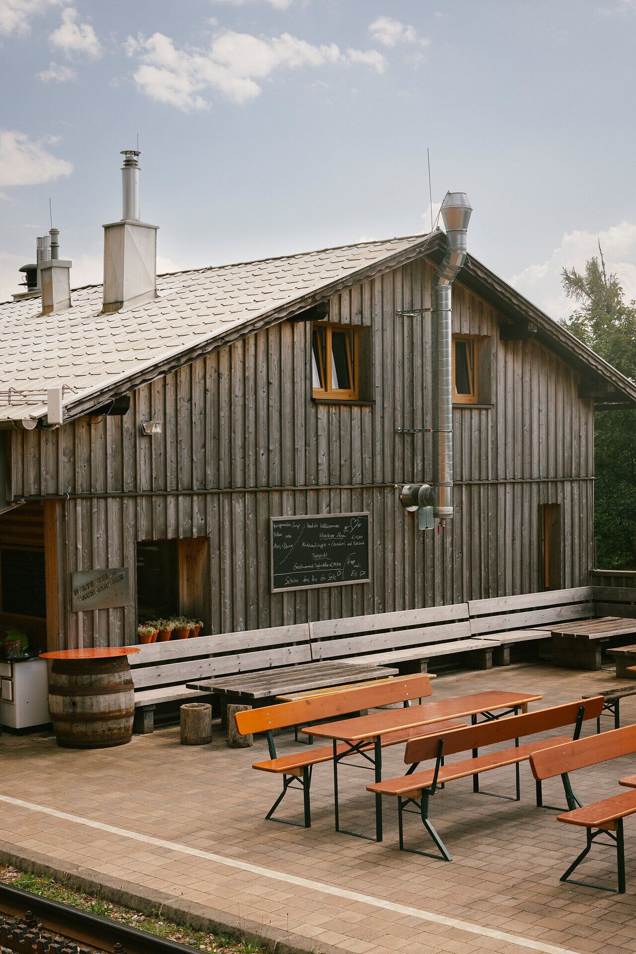 Baumgartner Shelter, with a terrace and benches in front of the wooden building