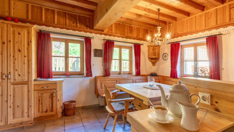 Traditional-style dining area with wooden furniture and red curtains.