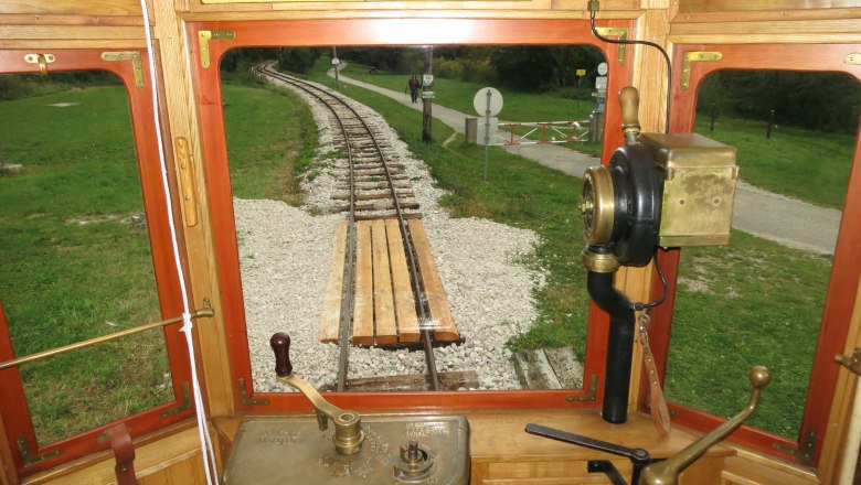 View of the tracks and landscape from a historic train driver's cab.