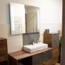 Modern bathroom with wooden cabinets, washbasin and mirror.