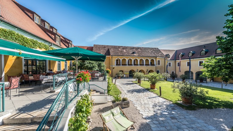 Inner courtyard of the Althof Retz with terrace, parasols and garden furniture.