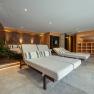 Interior view of a modern wellness area with loungers and plants.