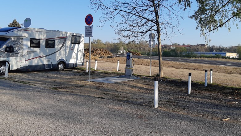 Motorhome parking space, © Stadtgemeinde Hollabrunn Motorhome on a pitch with signs and trees.