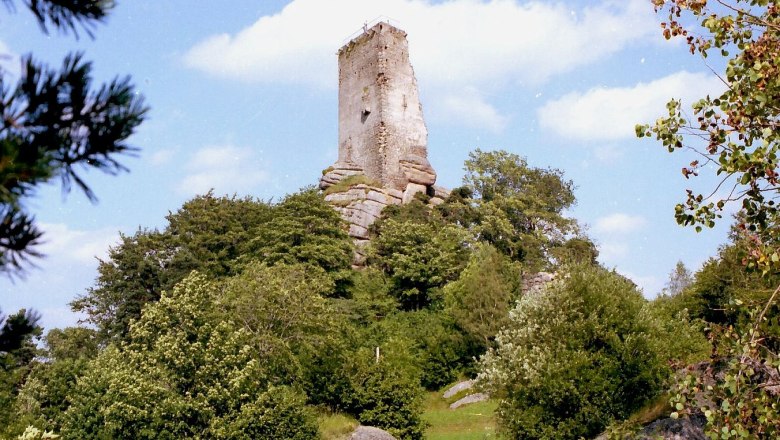 Arbesbach ruins on a wooded hill under a blue sky.