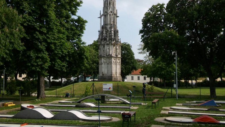Minigolf course with Gothic monument in the background.