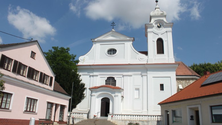 Wilfersdorf parish church with white façade and bell tower.