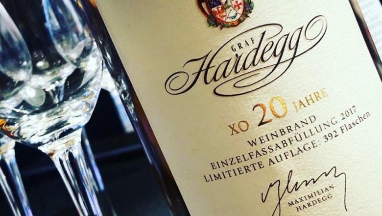 Close-up of a brandy bottle from Graf Hardegg with glasses in the background.