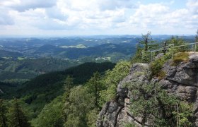 View from the castle stone wall over wooded hills and valleys.