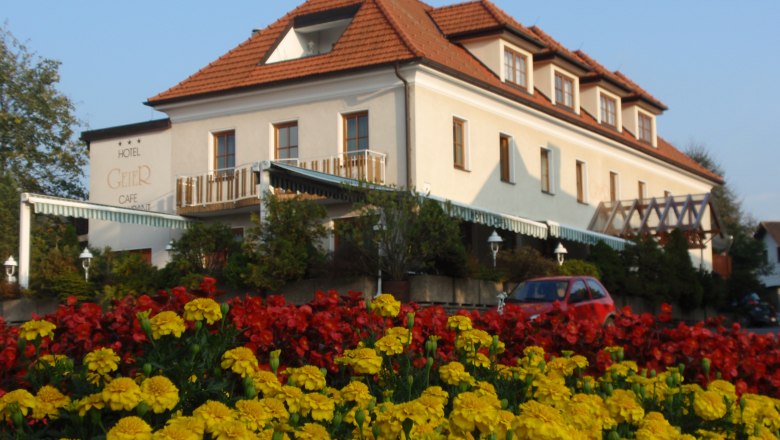 Hotel Geier in Bad Sch&ouml;nau with flower bed in the foreground.