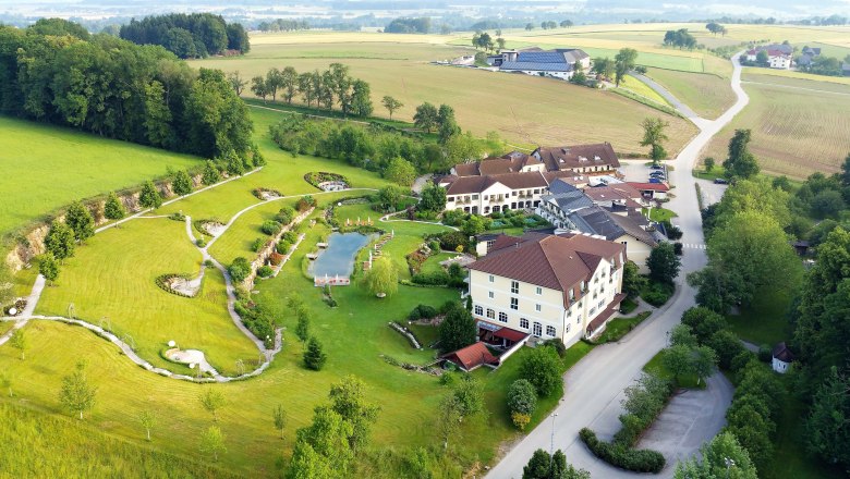 Aerial view of a resort with garden and pond in a rural setting.