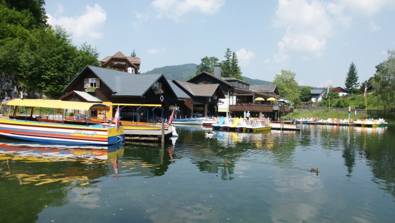 Boats and buildings on the shore of Lake Lunz on a sunny day.