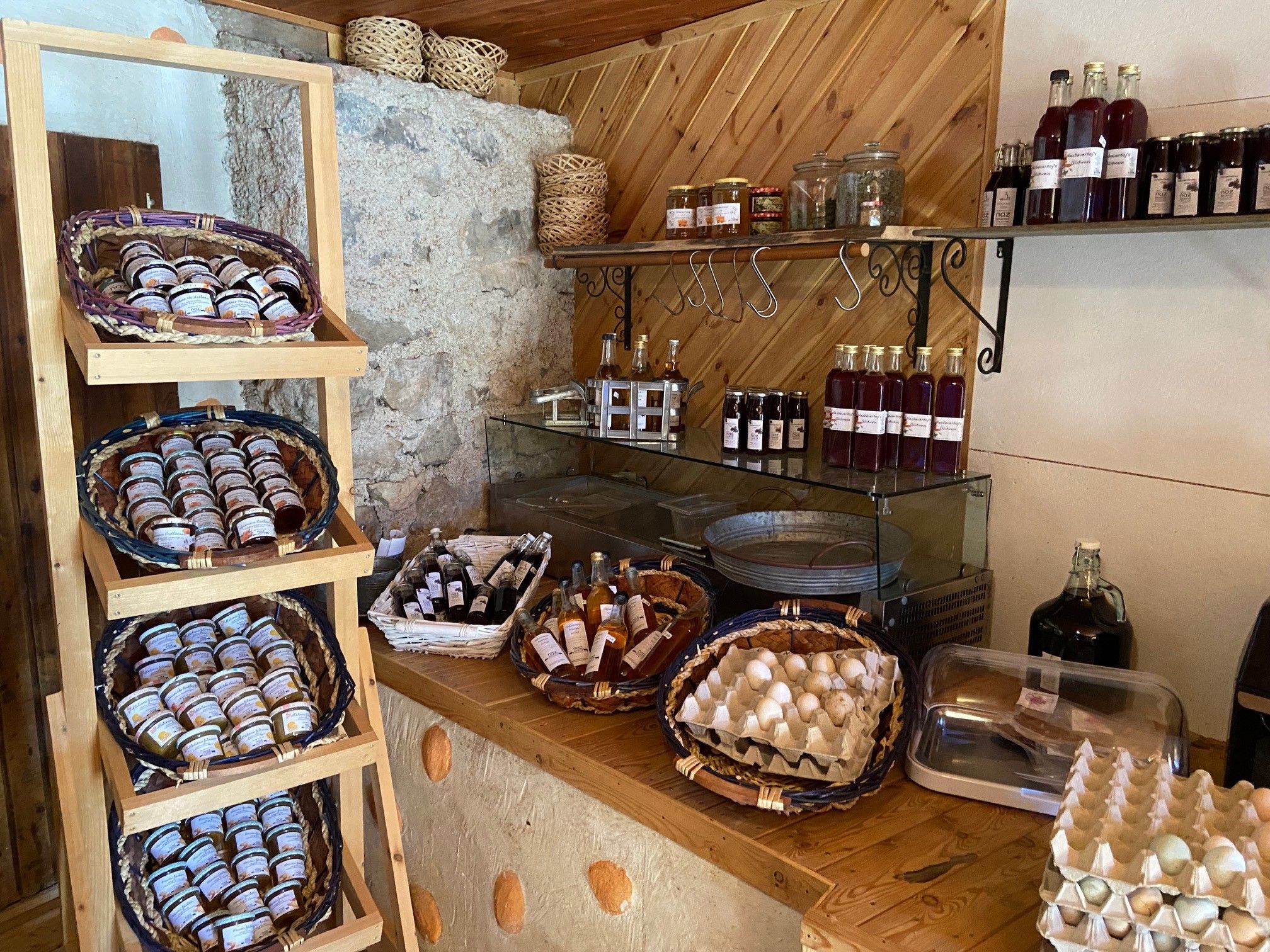Shelf with jams, bottles and eggs in a farm store.