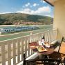 Balcony with table, wine and snacks, view of the river and passing ship.