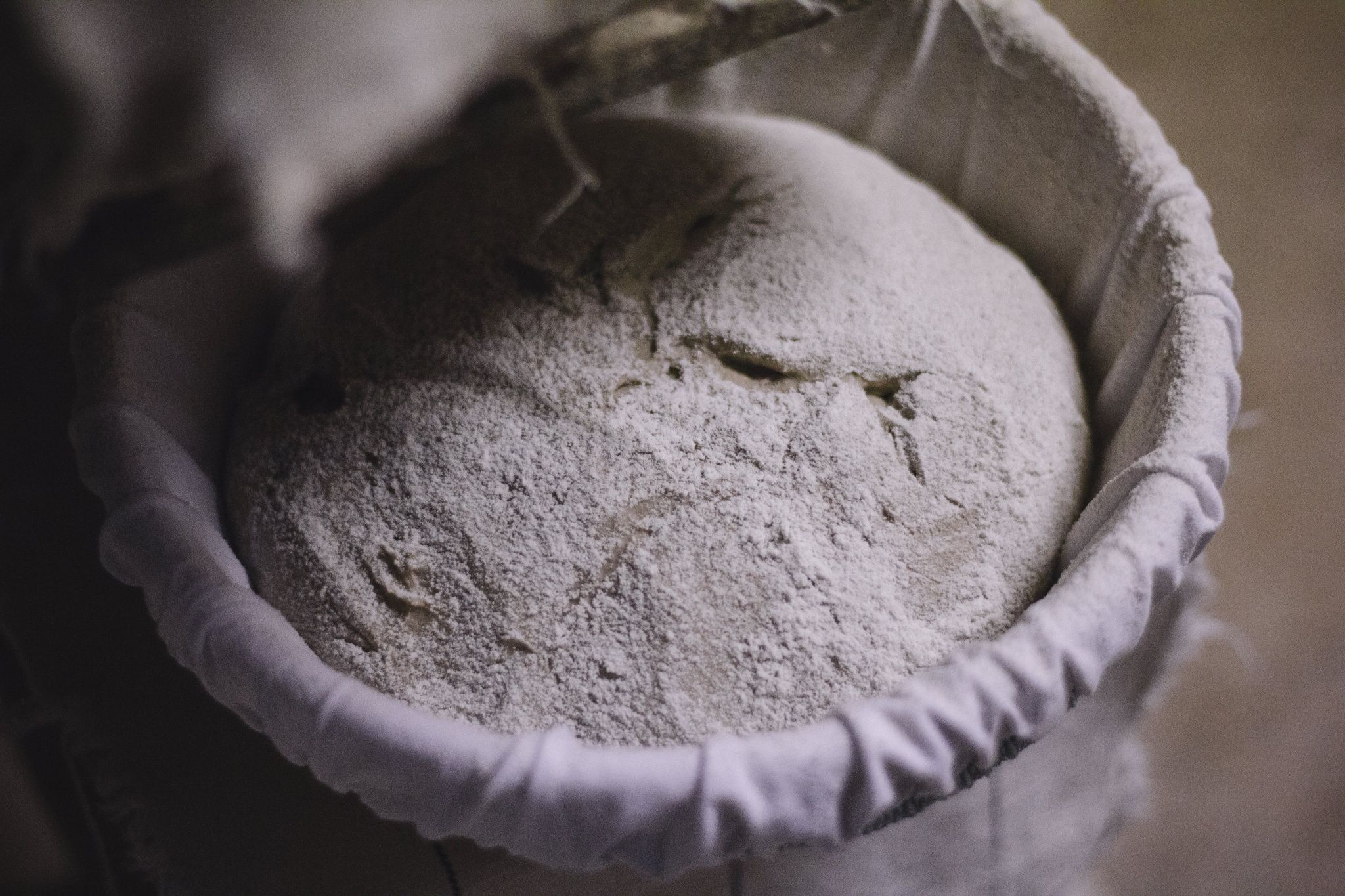 One dough piece in a floured proofing basket.