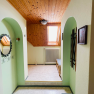 An anteroom with wooden ceiling, skylight, mirror and bench.