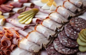 Various types of sausage and meat served on a plate.