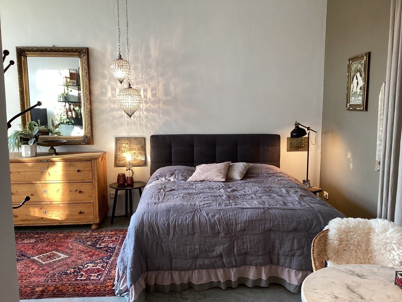 Cozy bedroom with double bed, wooden furniture and oriental carpet.