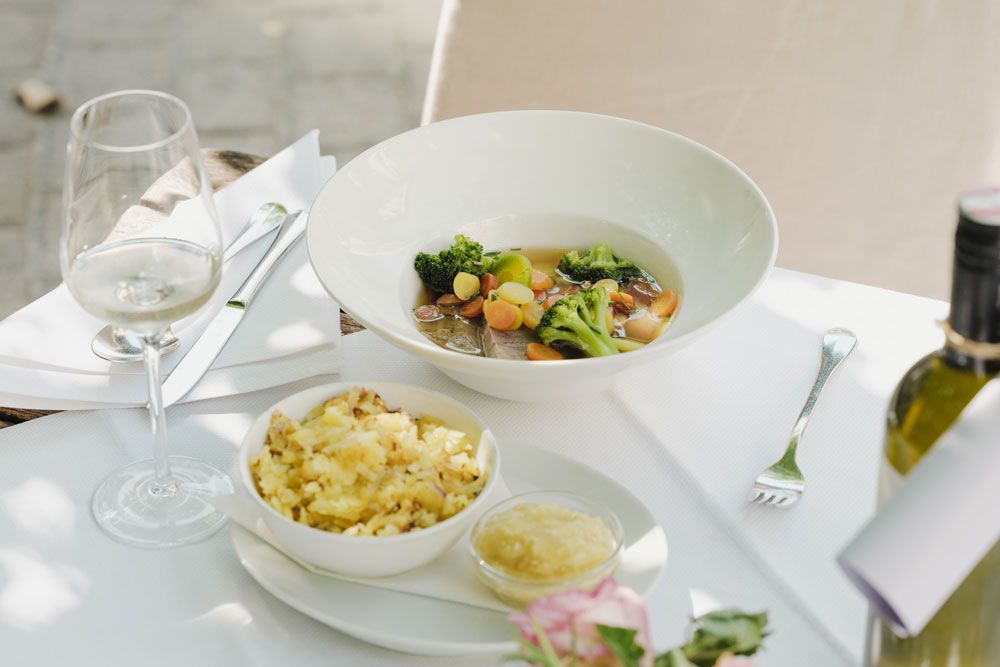 Elegant dish with meat, vegetables, potatoes and white wine.