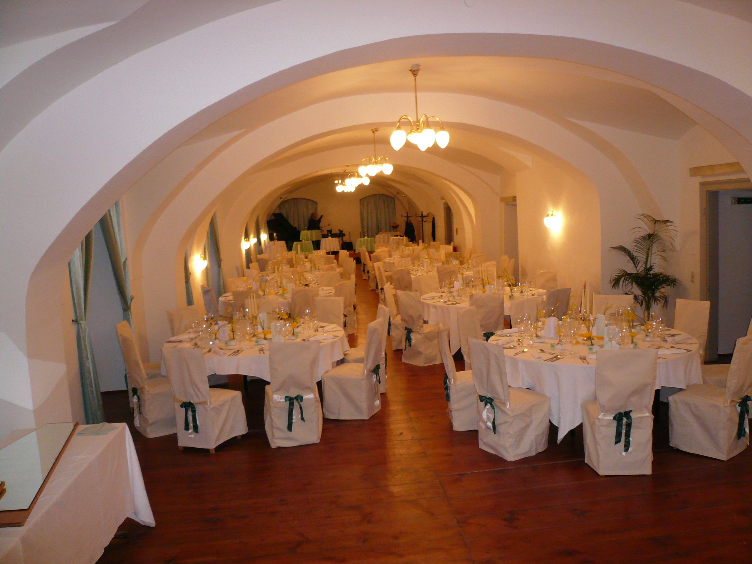 Elegant ballroom with set tables and chairs in Gloggnitz Castle.