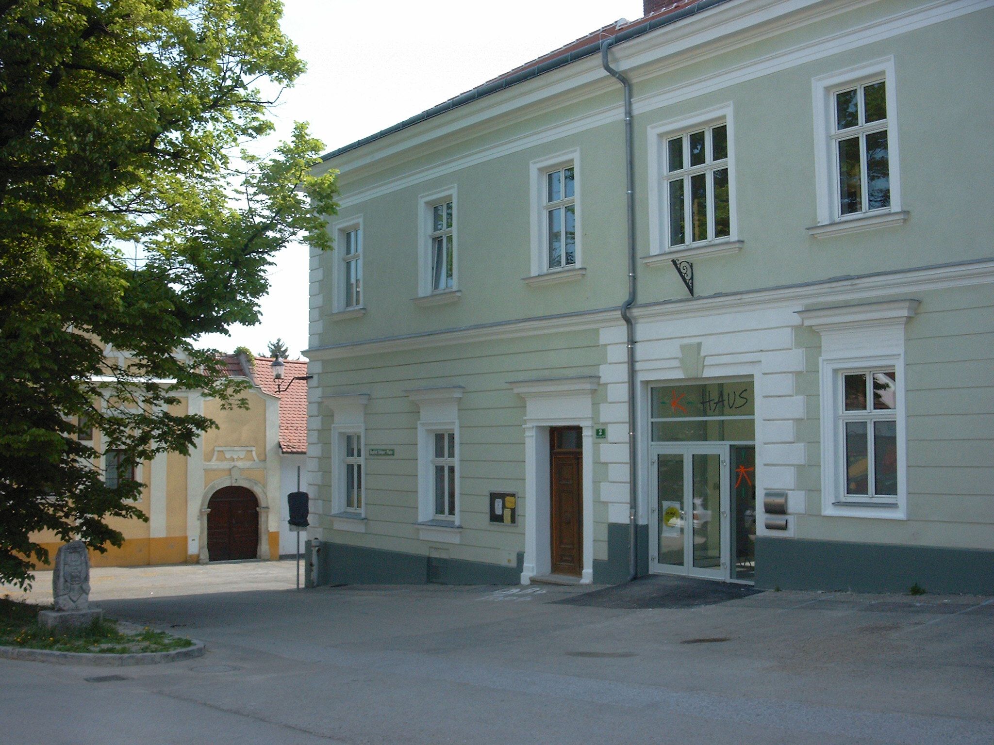 A two-story, light green building with the word 'house' above the door.