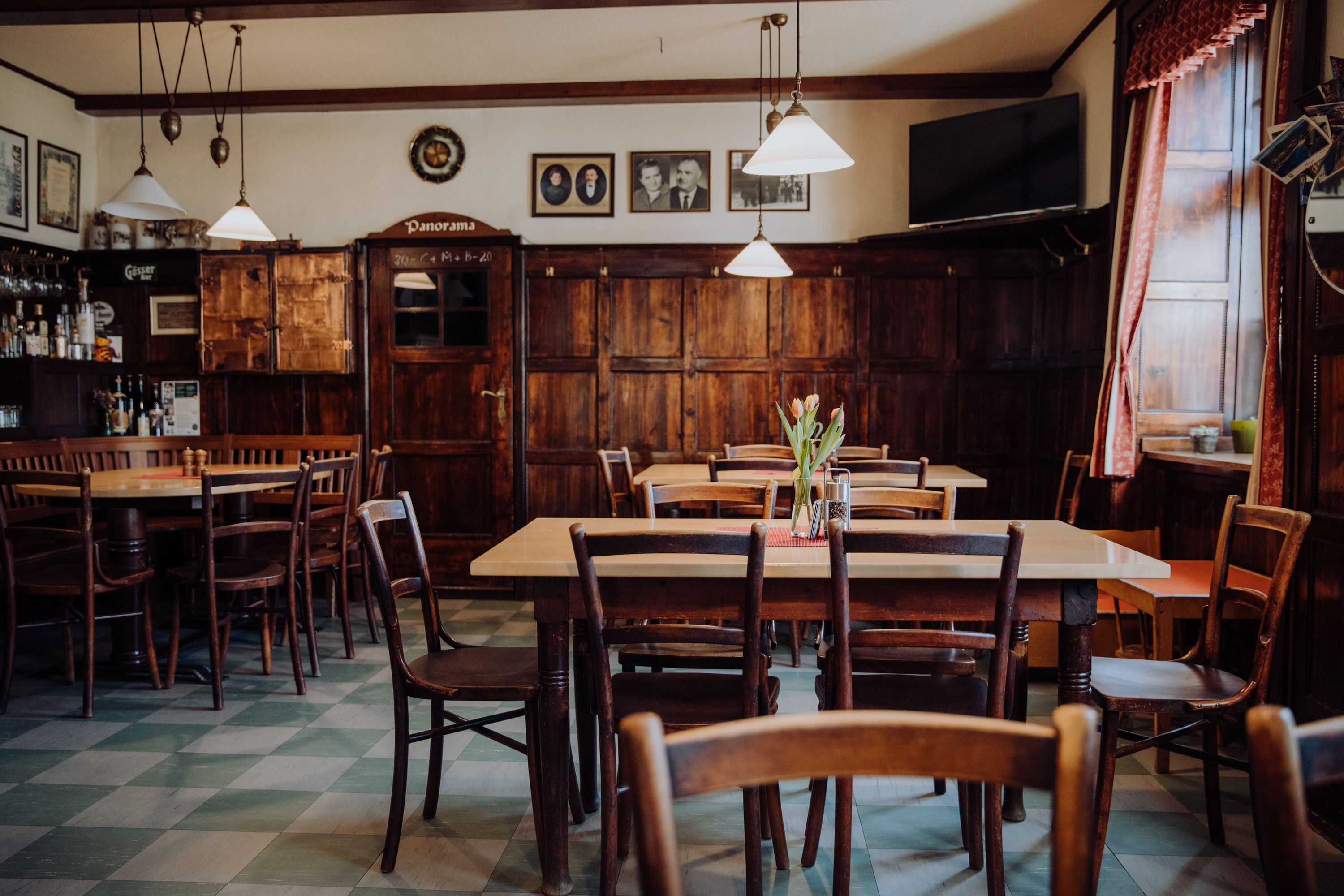 Cozy, traditional inn with wooden furniture and decorative pictures.