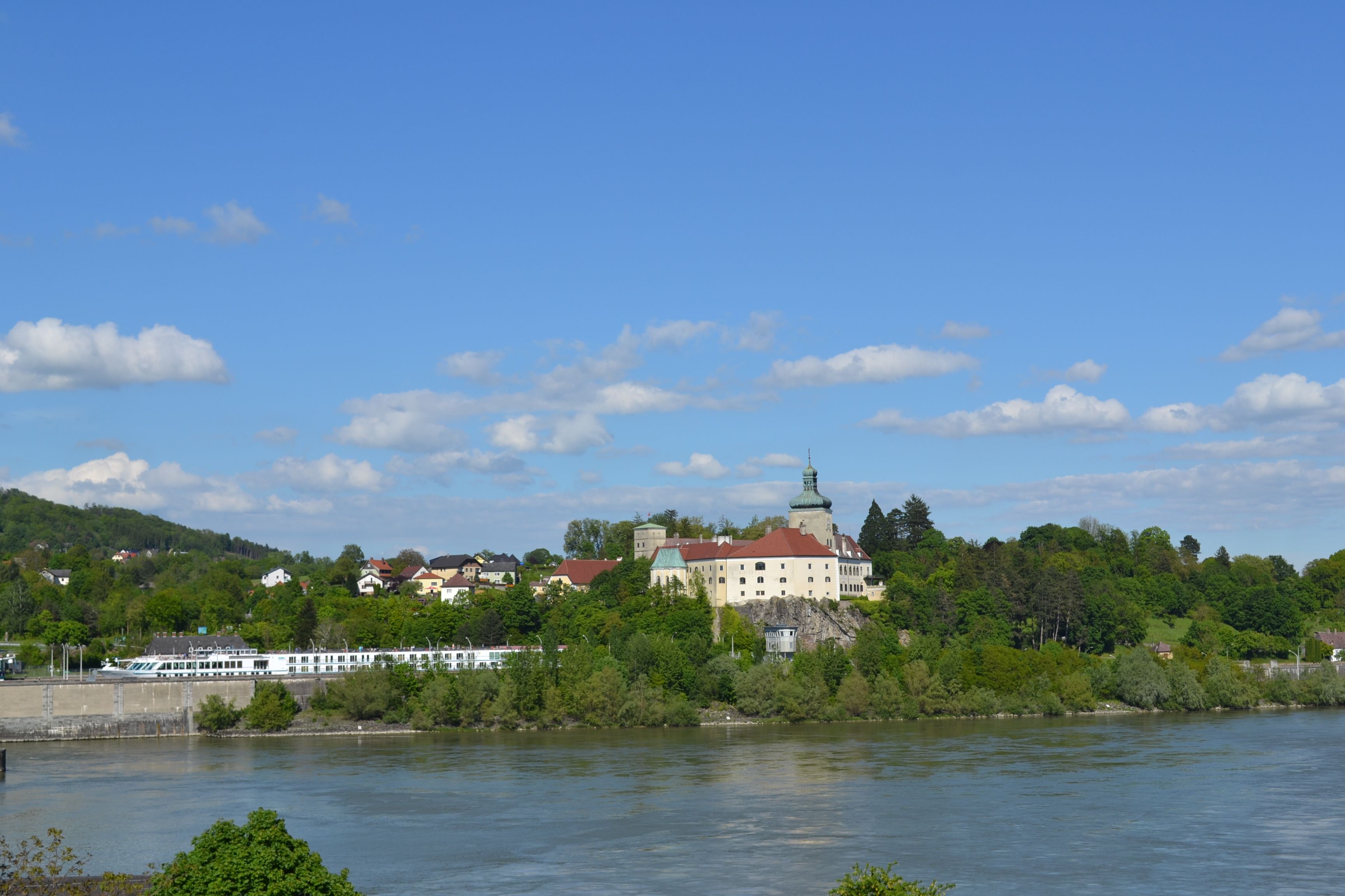 Persenbeug Castle and the surrounding area on a sunny day with a blue sky.