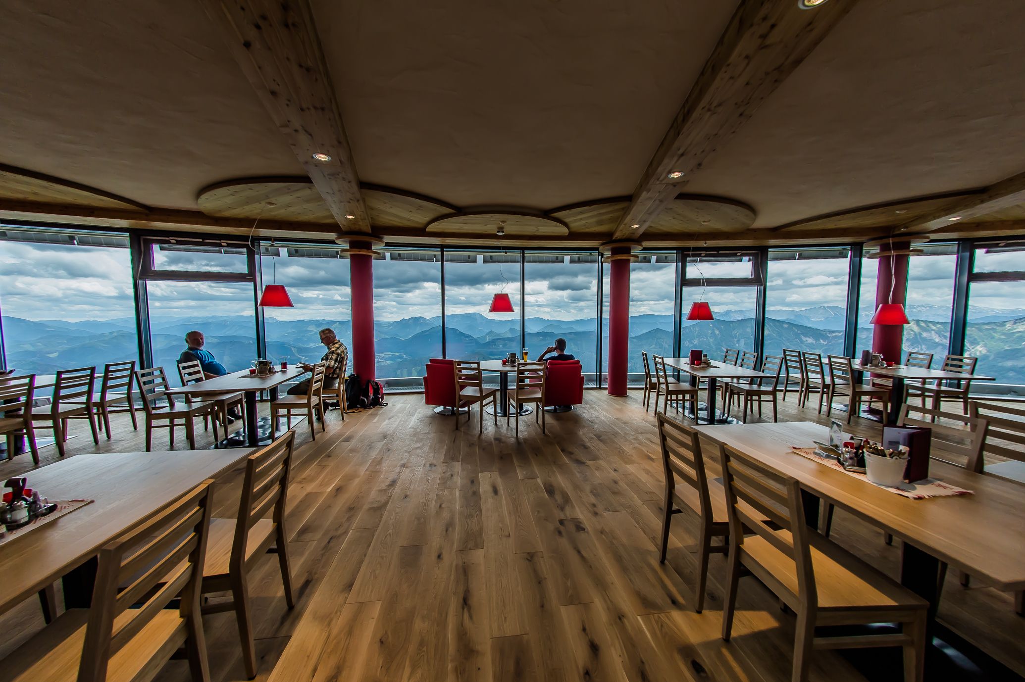 Interior view of a modern restaurant with panoramic windows and mountain views.