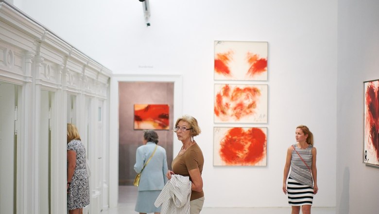 Visitors to the Arnulf Rainer Museum view works of art on white walls.
