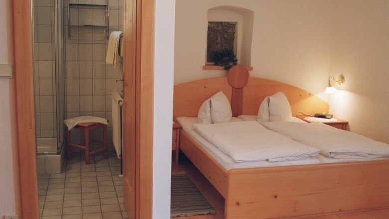 A cozy bedroom with double bed and adjoining bathroom.