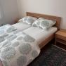 Bedroom with double bed, wooden furniture and carpet.