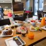 Breakfast table with pastries, cold cuts, cheese, fruit and juice in a modern caf&eacute;.