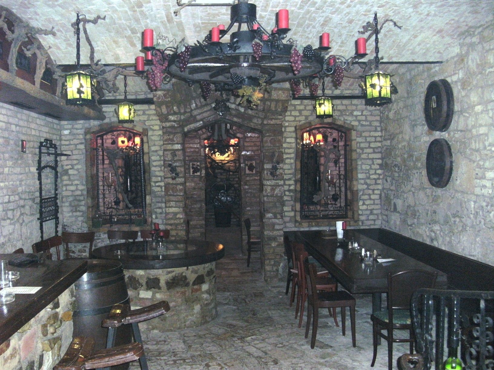 A rustic wine tavern in the cellar with stone walls, wooden furniture and decorative lights.