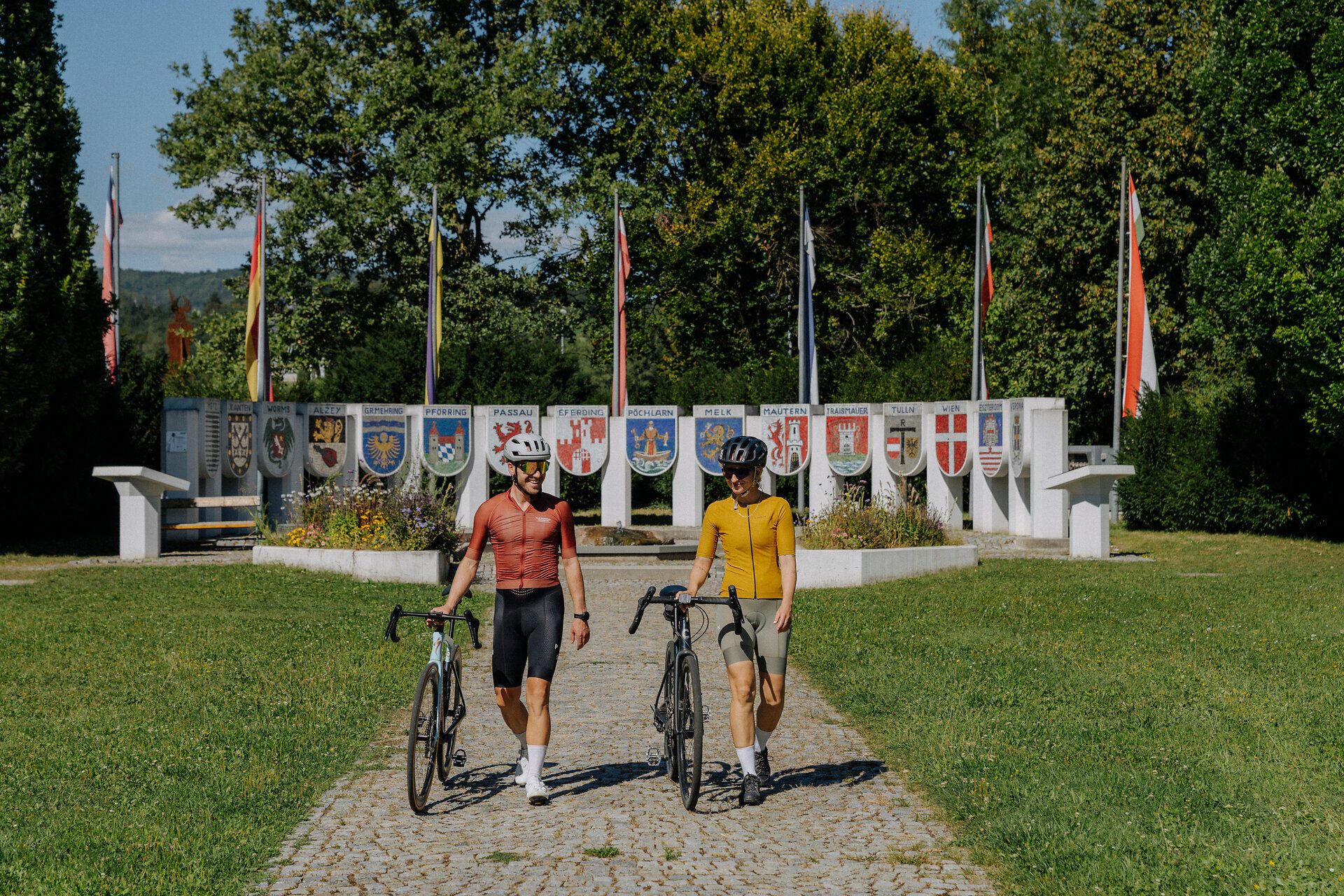 2 Cyclists in front of the Nibelungen monument in Pöchlarn in the Nibelungengau region