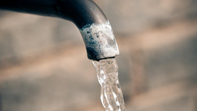 Close-up of a tap with flowing water against a blurred background.