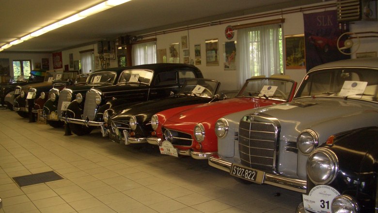 A row of vintage cars in a museum.