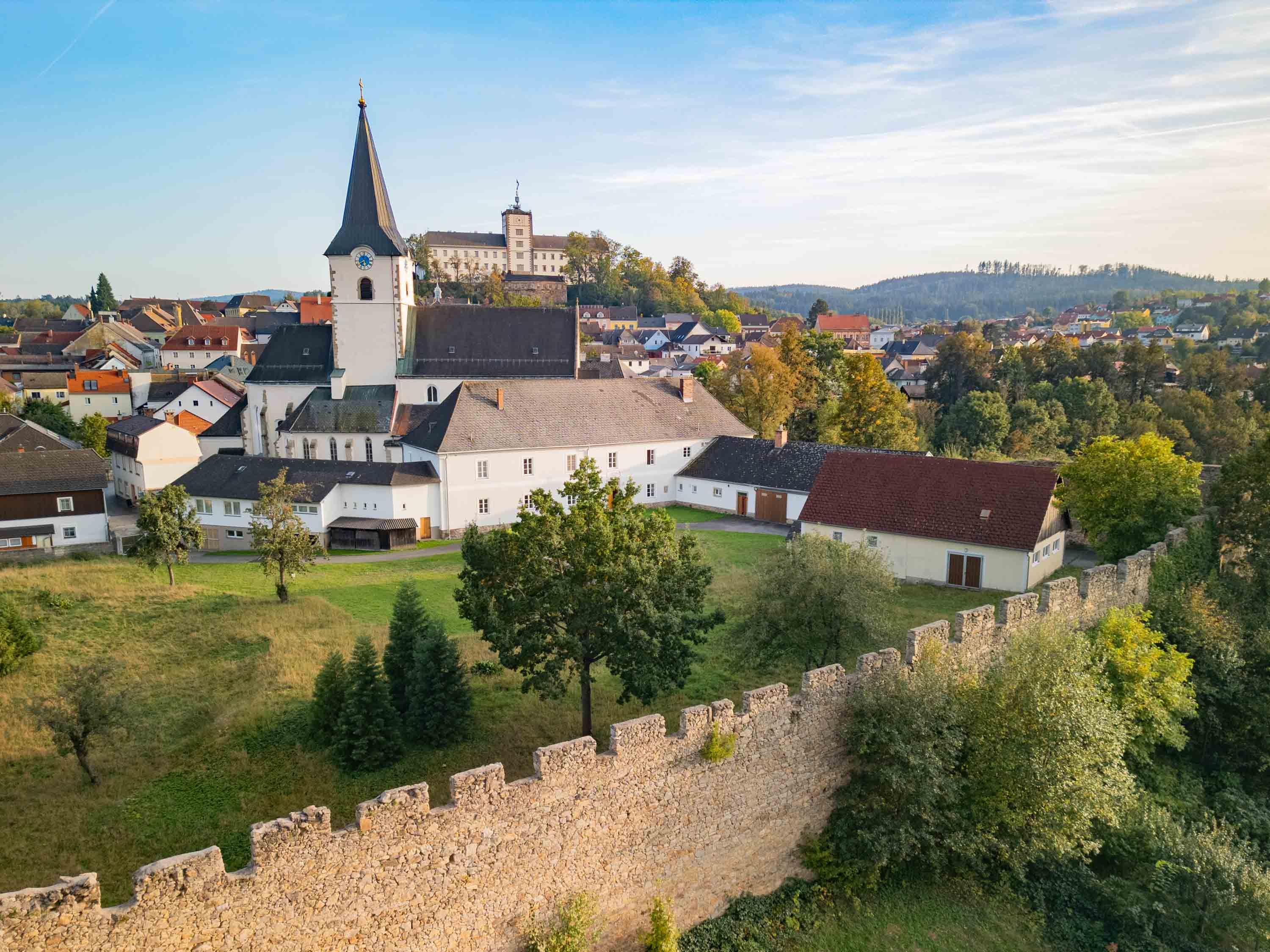 Aerial view of a town with church and town wall in the foreground.