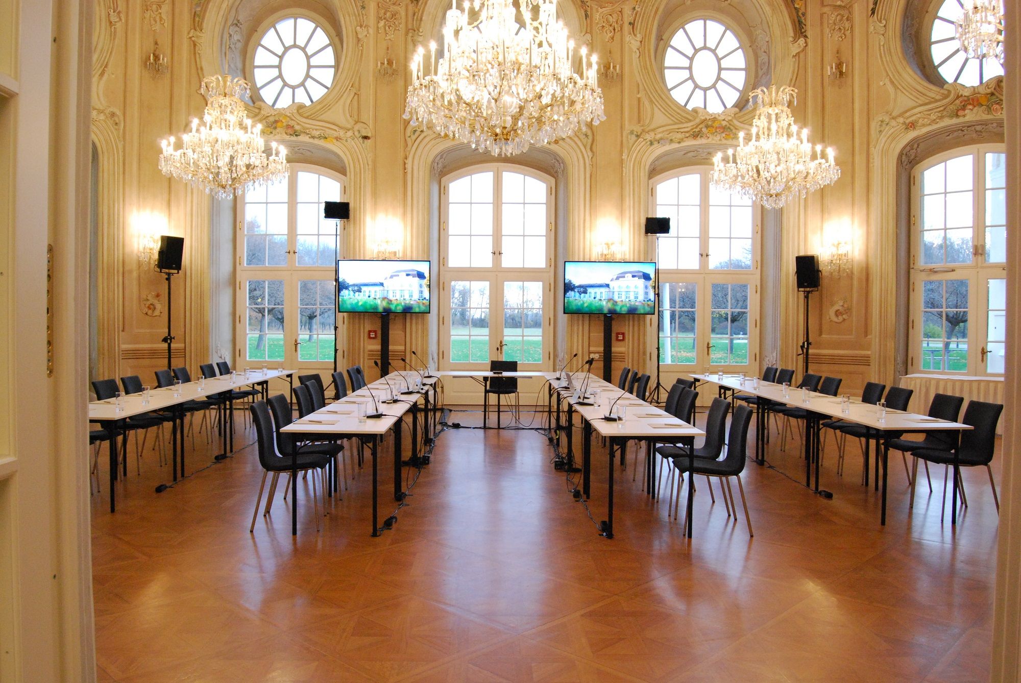 Elegant conference room with chandeliers and large windows.