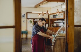 A man in a cozy living room operates a jukebox.