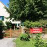 A house with a garden and a "Pension Lindenhof" sign on the wooden fence.