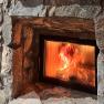 A burning fireplace built into a stone wall.