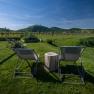 Two sun loungers on a meadow with a view of the vineyards.