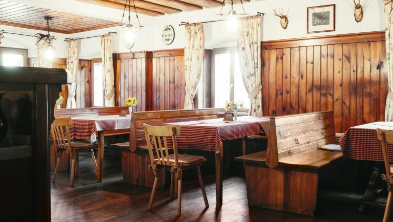 Cozy dining room with wooden furniture and checkered tablecloths.