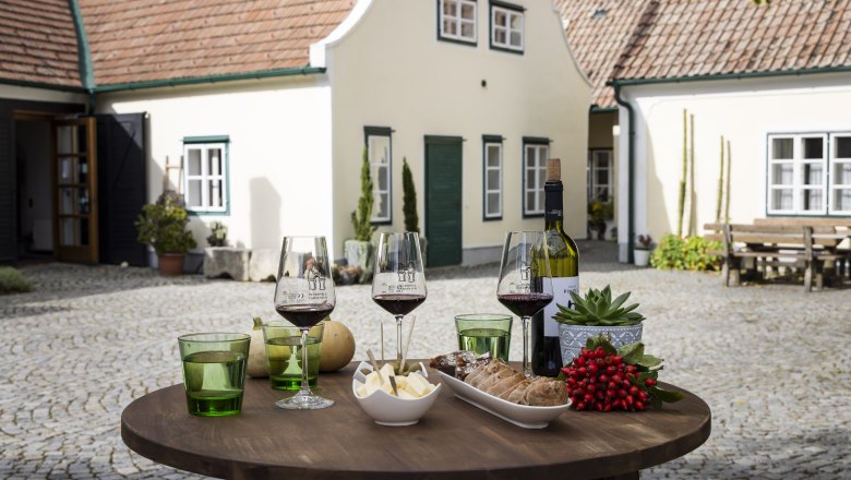 Table with wine glasses, cheese and bread at the winery in the courtyard