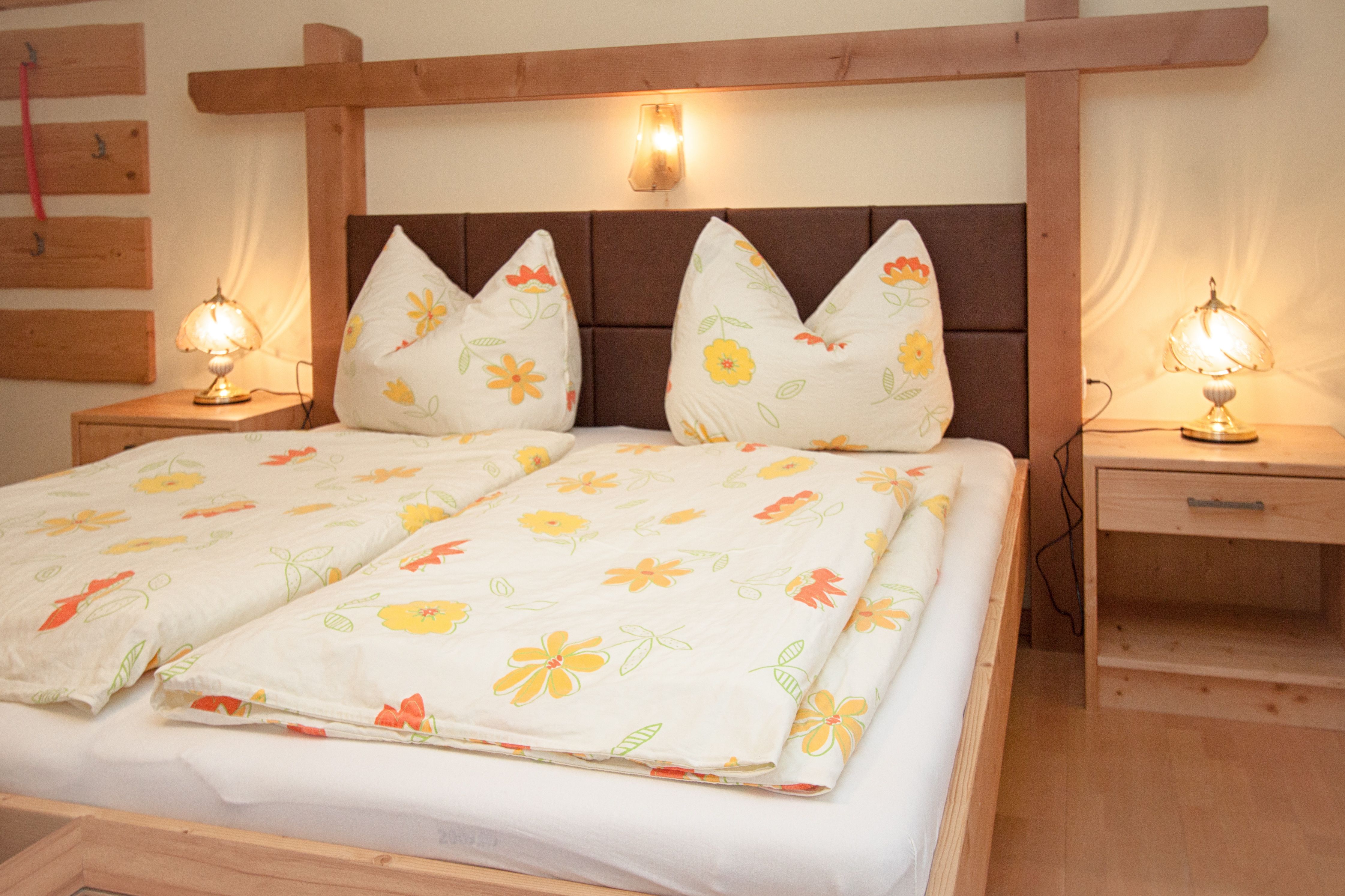 Cozy bedroom with double bed, floral bedding and bedside lamps.