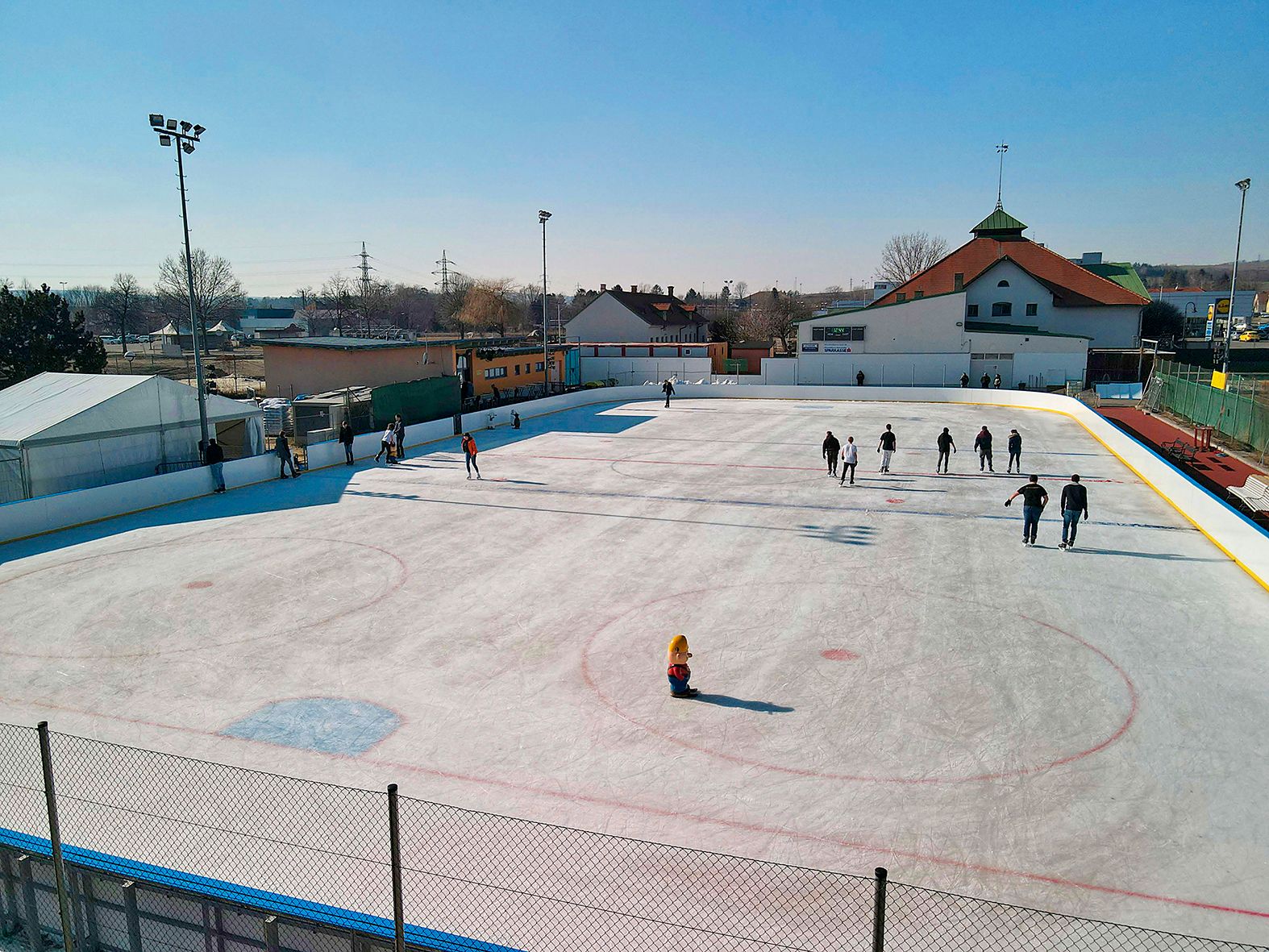 Ice rink with people in Hollabrunn in sunny weather.