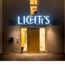 Entrance area of a building with illuminated sign 'LICHTI'S'.